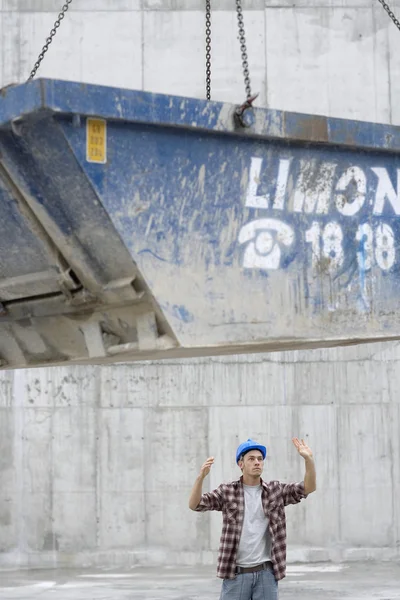 Construction worker directing movement of skip — Stock Photo, Image