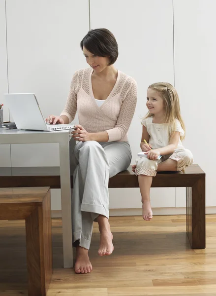 Madre mostrando hija portátil — Foto de Stock