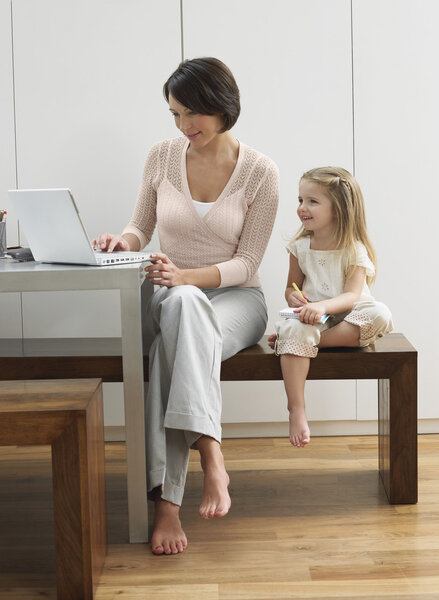 Mother showing daughter laptop