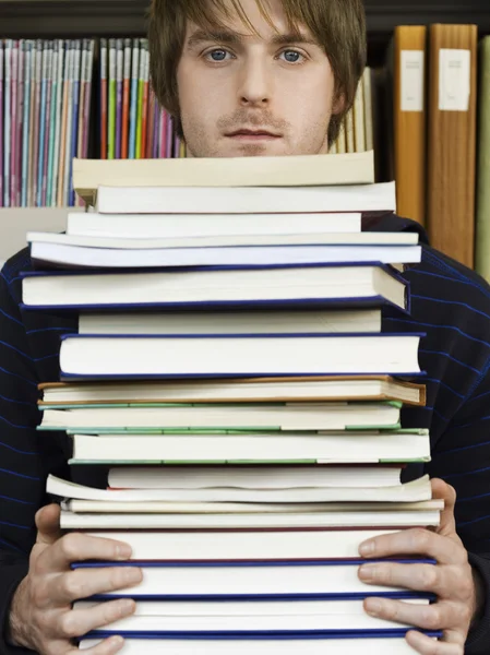 Jovem segurando livros — Fotografia de Stock