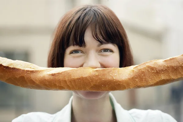 Vrouw bedrijf stokbrood — Stockfoto