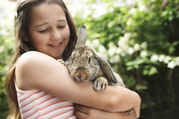 Girl holding bunny rabbit — Stock Photo, Image