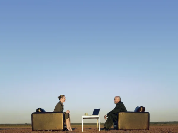 Empresários sentados em cadeiras na planície aberta — Fotografia de Stock