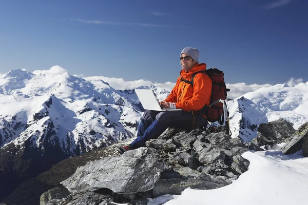 Climber using laptop on mountain — Stock Photo, Image