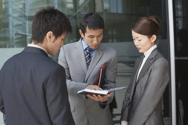 Businesspeople looking over documents — Stock Photo, Image