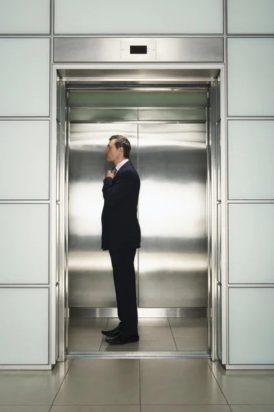 Geschäftsmann richtet Krawatte im Fahrstuhl auf — Stockfoto