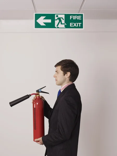 Empresário segurando extintor — Fotografia de Stock