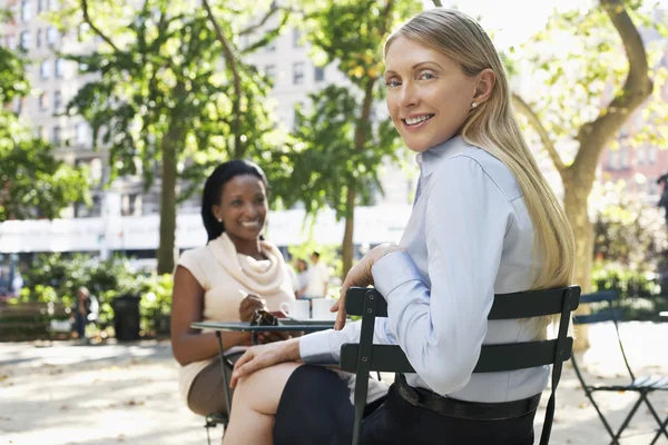 Female colleagues sitting at street cafe — Stock Photo, Image