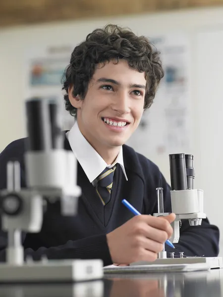 Gymnasiestudent genom Mikroskop — Stockfoto