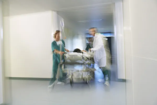 Ärzte bewegen Patienten auf Gurney — Stockfoto
