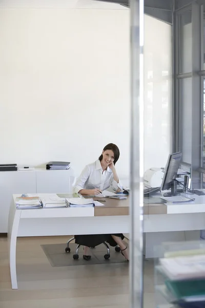 Businesswoman sitting in office. Royalty Free Stock Photos