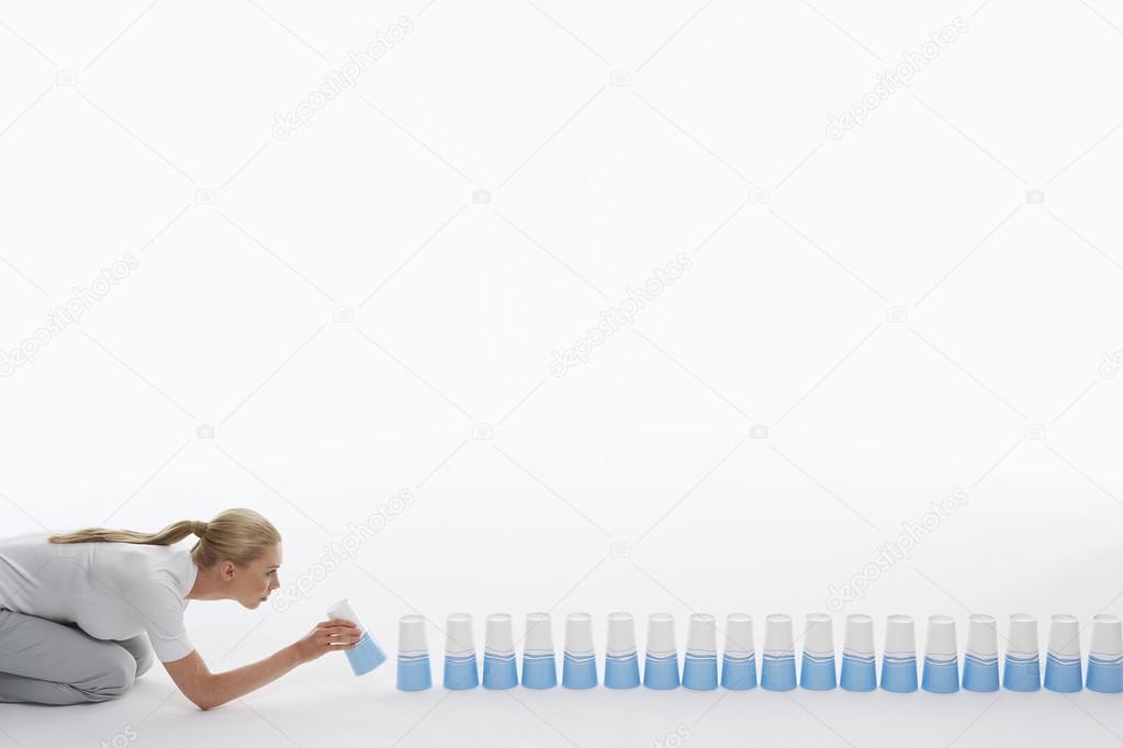 Woman lining up plastic cups on ground