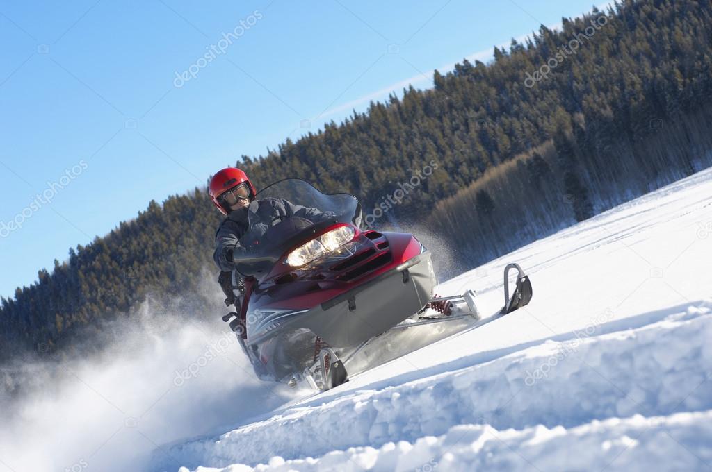 Man snowmobiling through snow