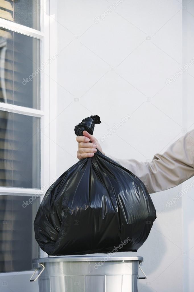 Man Taking Garbage Out of Can
