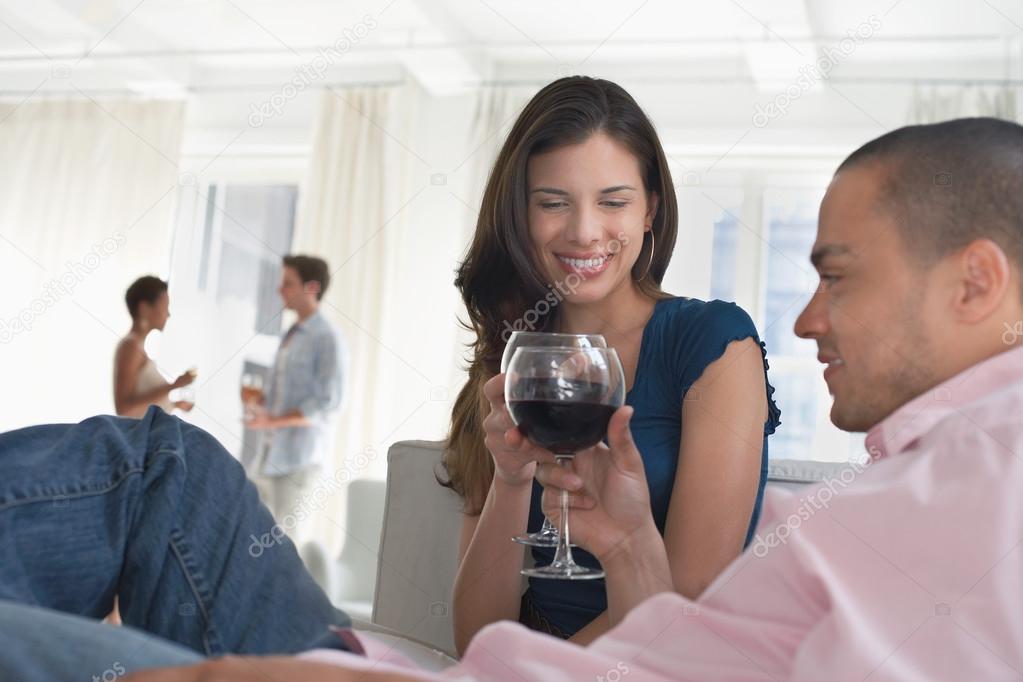Couples drinking wine in living room