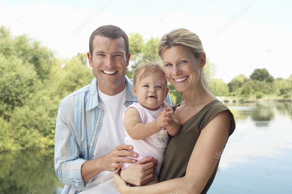 Couple with child standing by lake