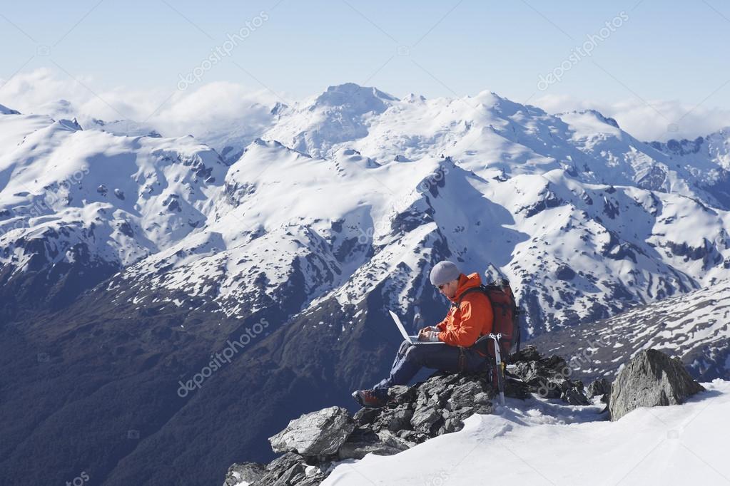 Mountain climber using laptop