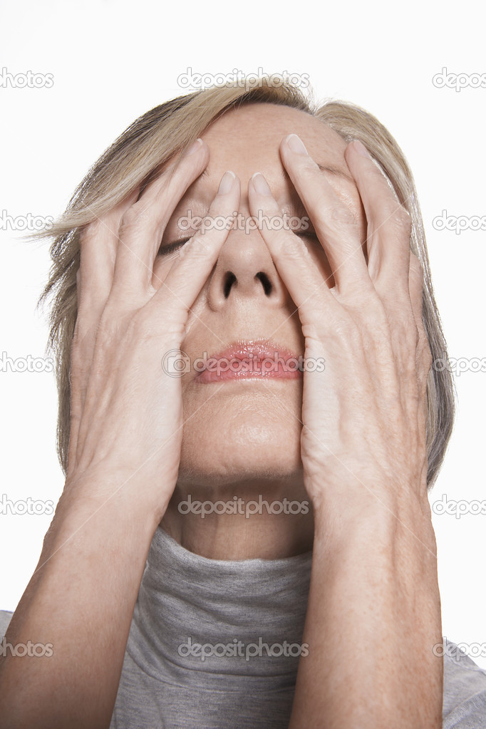 Senior woman with hands on face