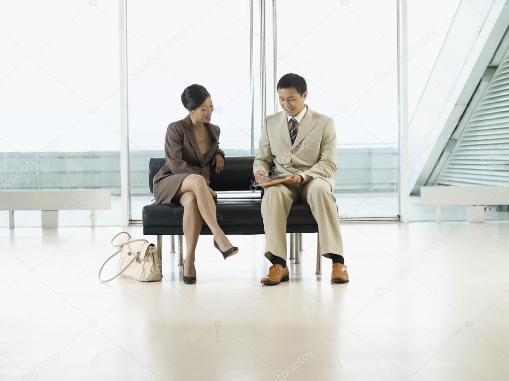Businesspeople Sitting on Bench in airport