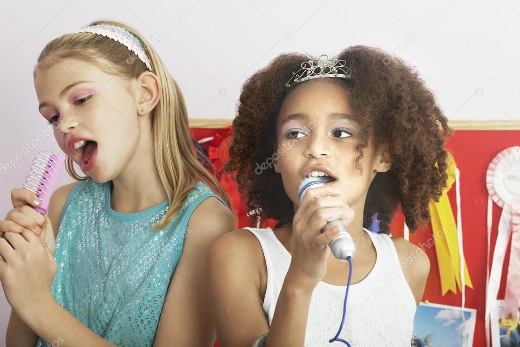 Girls using brushes microphones
