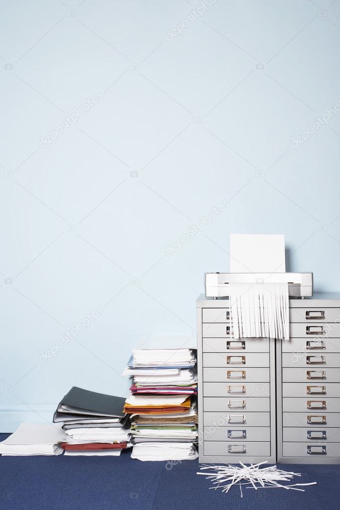Shredder and stack of paperwork