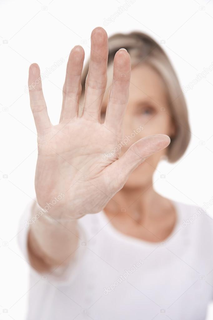 Senior woman holding up palm of hand
