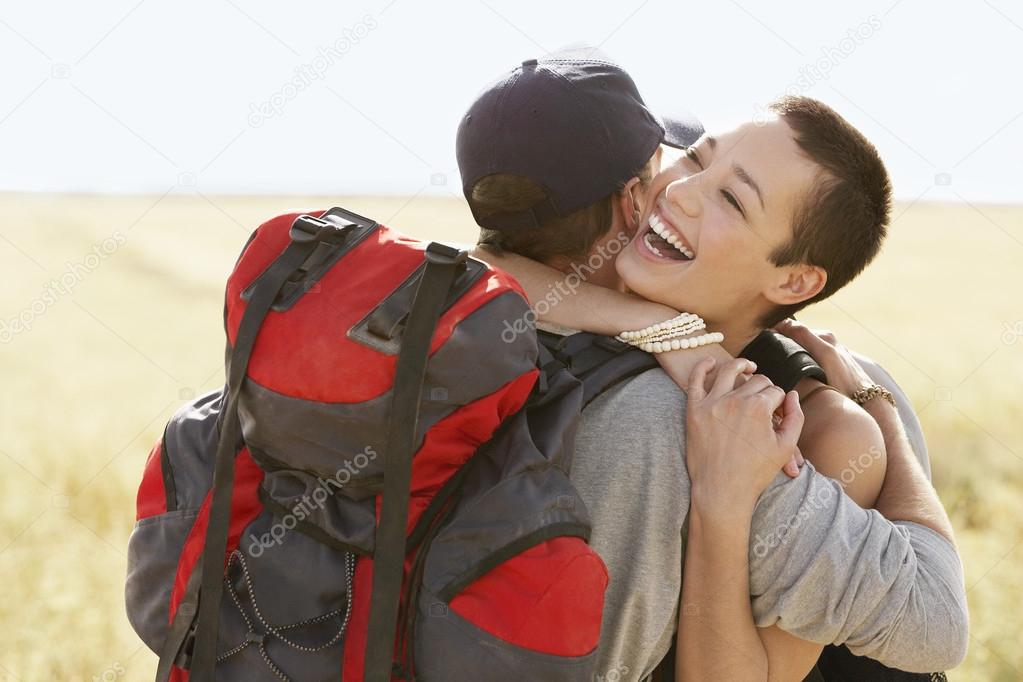 Couple of hikers hugging in field