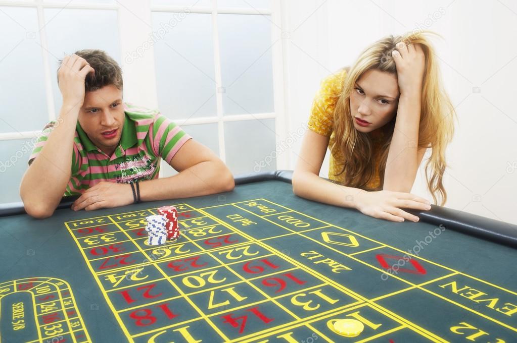 Man and woman losing on roulette table