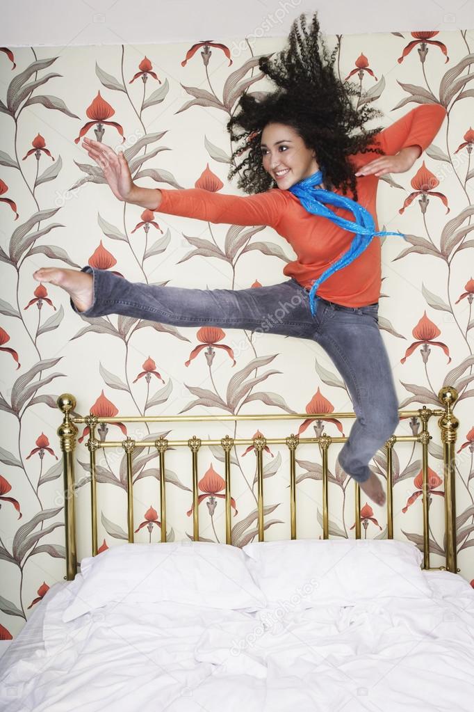 Teenage Girl kicking jumping on bed