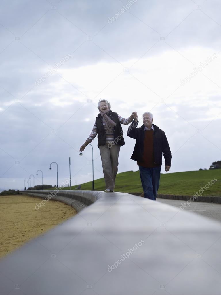 Senior couple walking holding hands