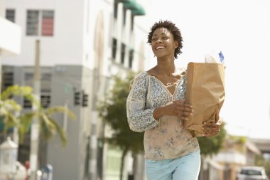 Young woman carrying groceries clipart