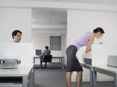 Businessman watching female colleague clipart