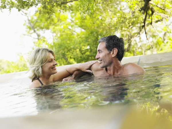 Пара обнимающихся в бассейне улыбающихся — стоковое фото