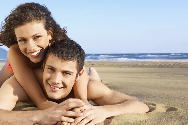 Woman lying on back of man — Stock Photo, Image