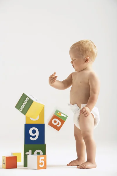 Baby knackar över block — Stockfoto