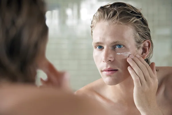 Hombre aplicando crema — Foto de Stock