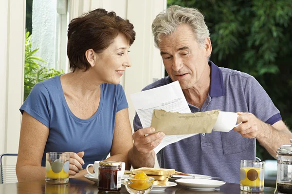 Paar schaut beim Frühstück auf Rechnung — Stockfoto