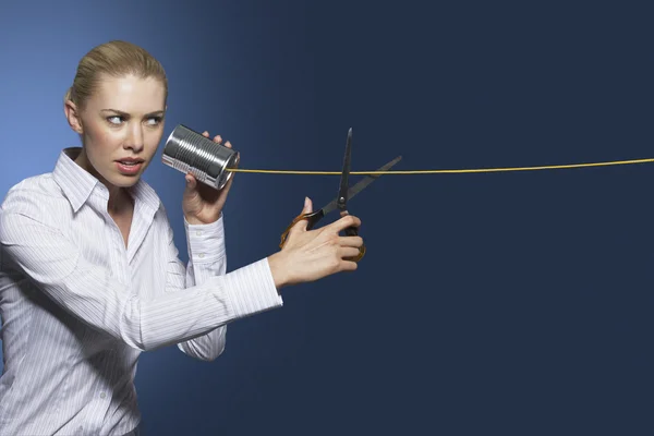 Woman cutting line on tin can string phone — Stock Photo, Image