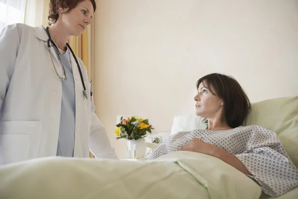 Médico conversando com paciente em cama de hospital — Fotografia de Stock