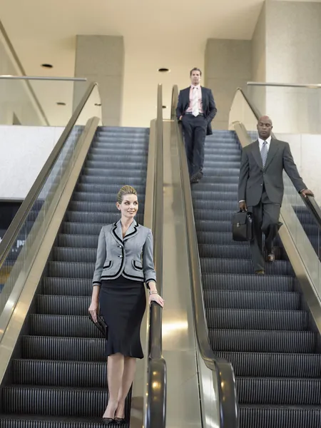 Businesspeople on escalators — Stock Photo, Image