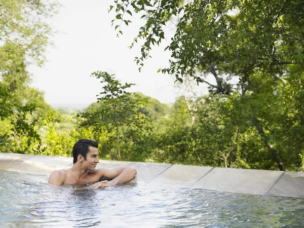 Homme assis dans la piscine — Photo