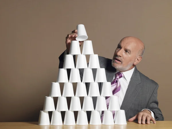 Affärsman byggnad pyramid av koppar — Stockfoto