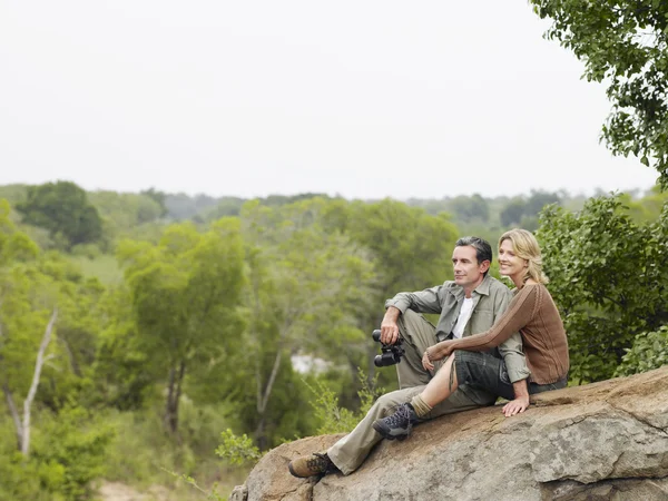 Paar sitzt auf Felsen — Stockfoto