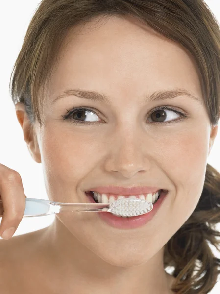 Молода жінка чистить зуби — стокове фото