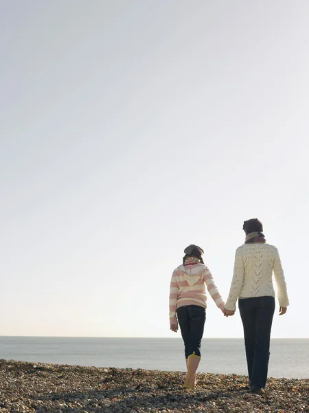 Moeder en dochter hand in hand op strand — Stockfoto