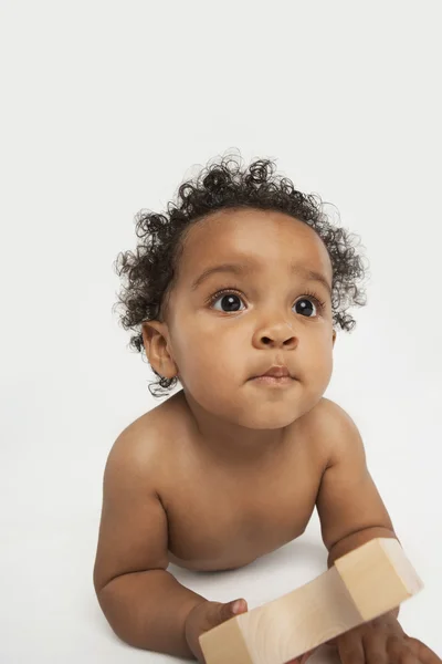 Bebê segurando um bloco de construção — Fotografia de Stock