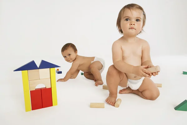 Bebé y niña jugando con bloques de construcción — Foto de Stock