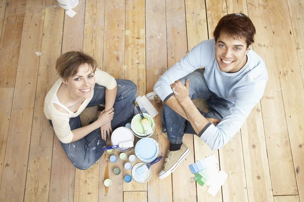 Couple sitting on floorboards — Stock Photo, Image