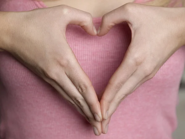 Vrouw vormt hart vorm met handen — Stockfoto