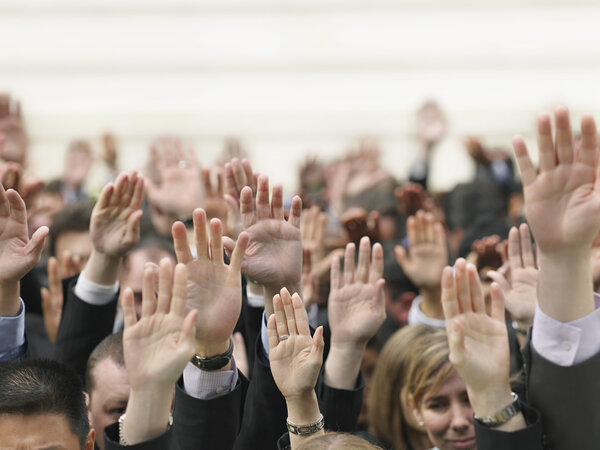 Crowd of people raising hands